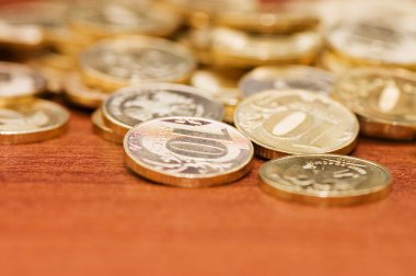 Golden coins on a wooden table clipart