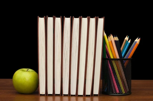Pilha de livros e maçã em uma mesa de madeira — Fotografia de Stock