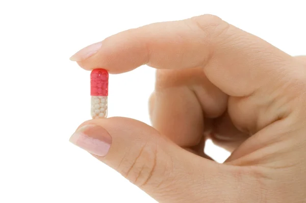 Hand mit einer Pille auf weißem Hintergrund — Stockfoto