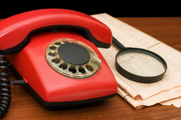 Czerwony telefon na drewnianym stołem — Zdjęcie stockowe