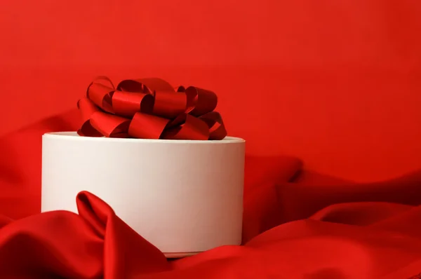 Doos met een gift op een rode stof — Stockfoto