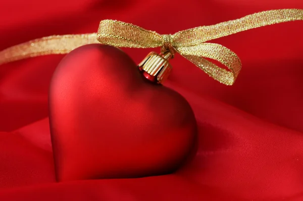 Corazón de juguete en una tela roja — Foto de Stock