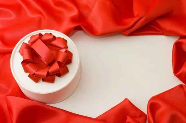 Caja con un regalo en una tela roja —  Fotos de Stock