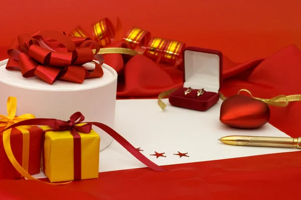 Boîte avec un cadeau sur un tissu rouge — Photo