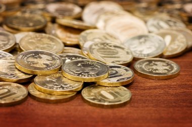 Golden coins on a wooden table clipart