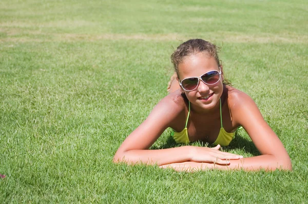 La muchacha joven se acuesta sobre la hierba — Foto de Stock