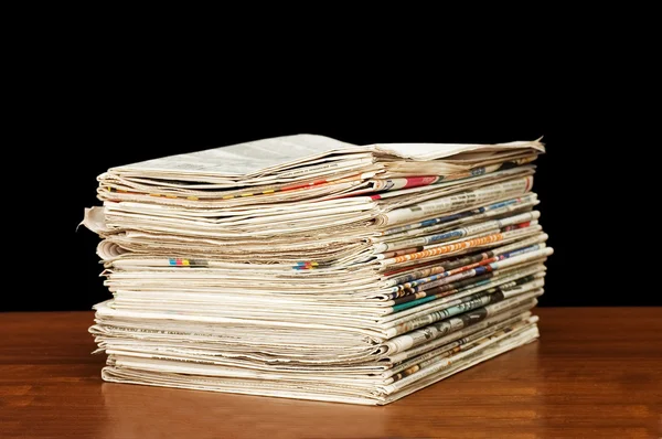 Montón de periódicos sobre una mesa de madera — Foto de Stock