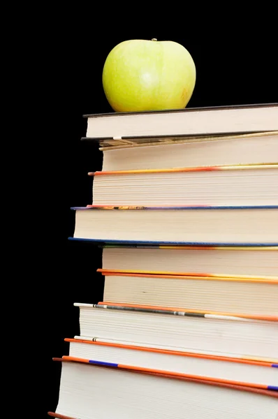 Montón de libros y manzana Sobre un fondo negro —  Fotos de Stock