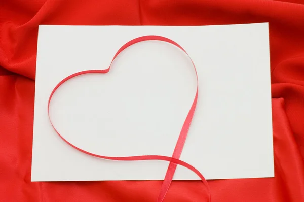 Czysty arkusz papieru na czerwone tkaniny — Zdjęcie stockowe