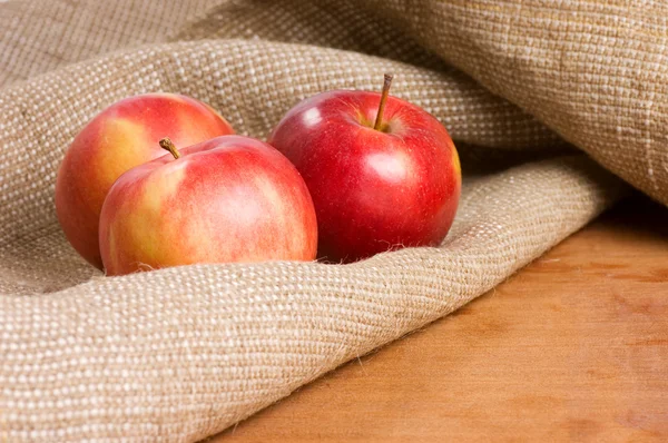 Pommes sur un sac sur une table en bois — Photo