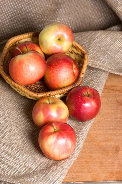 Яблоки на мешке на деревянном столе — стоковое фото