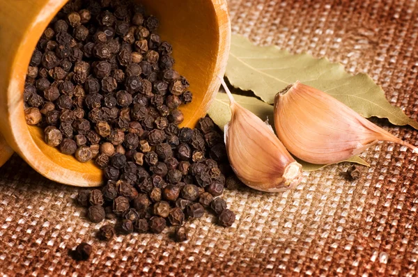 Black Peppercorns with garlic and a bay leaf — Stock Photo, Image