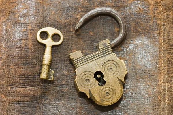 La vecchia serratura e la chiave su uno sfondo di pelle — Foto Stock