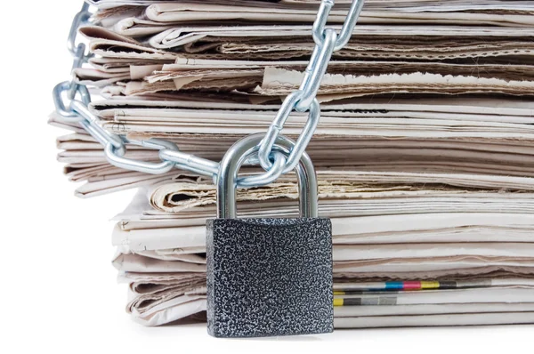 Pile of newspapers with chains, on white — Stock Photo, Image