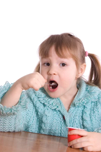 Девочка ест йогурт. — стоковое фото