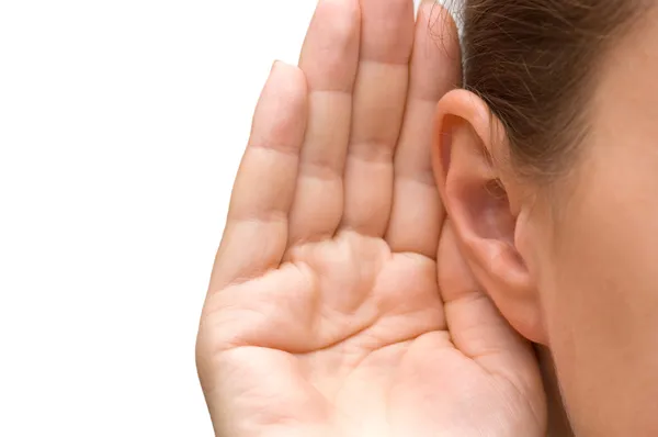 Menina ouvindo com a mão em uma orelha — Fotografia de Stock