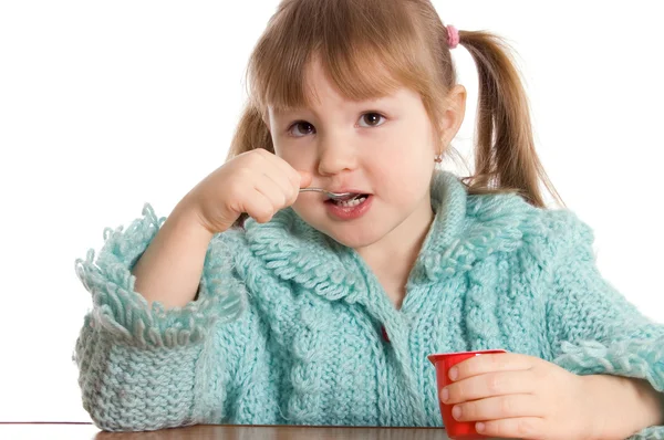 Het kleine meisje eet yoghurt — Stockfoto