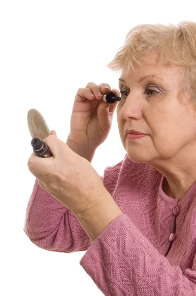 Die ältere Frau schminkt sich — Stockfoto