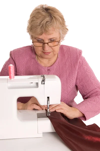 stock image The elderly woman sews on the sewing machine