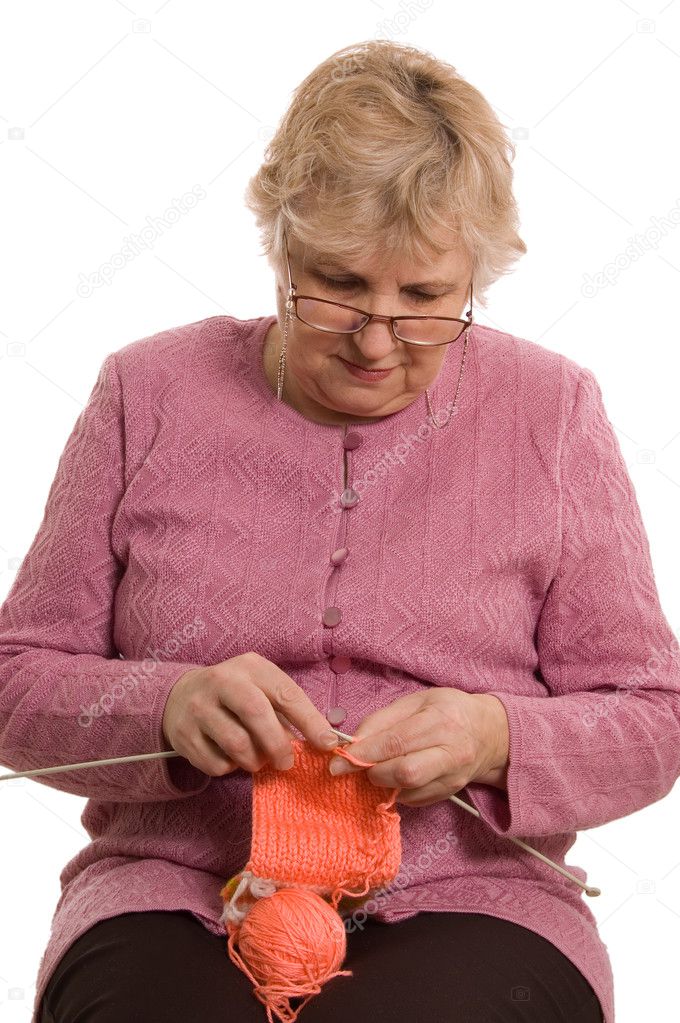 The elderly woman knits isolated on white