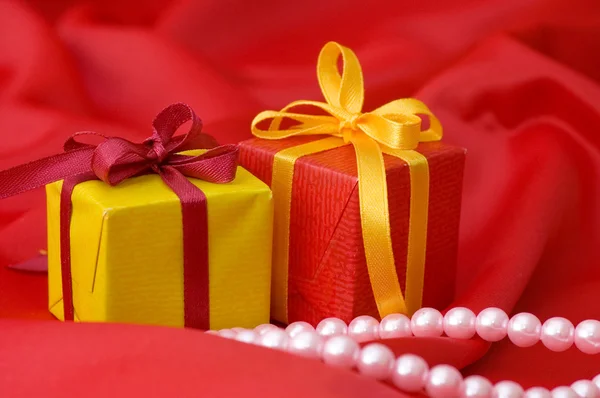 Box med en gåva på ett rött tyg — Stockfoto