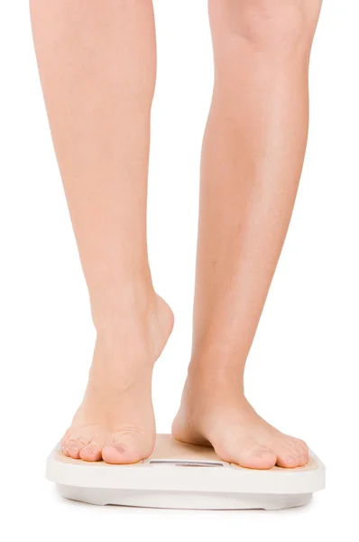 Vrouwelijke voeten op schalen geïsoleerd op wit — Stockfoto