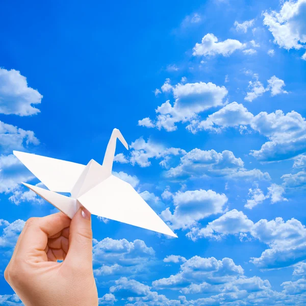 Бумажный кран на фоне голубого неба — стоковое фото