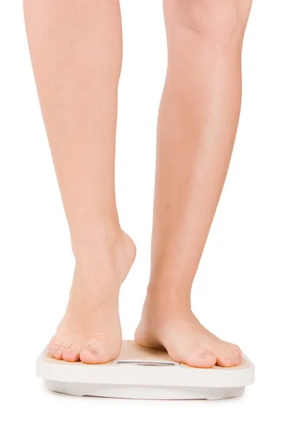 Female feet on scales isolated on white — Stock Photo, Image