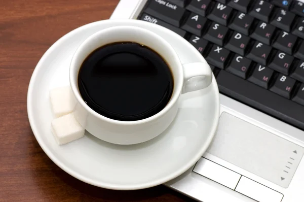 Чашка кофе на ноутбуке — стоковое фото