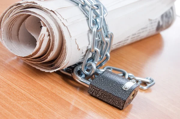 Newspapers with chains On a wooden table — Stock Photo, Image