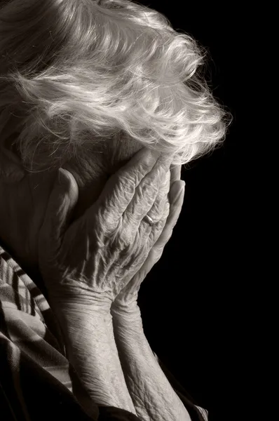 Trieste oude vrouwen met haar handen in haar gezicht is ontzetting — Stockfoto