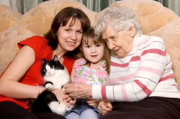 Familie auf dem Sofa mit einer Katze — Stockfoto