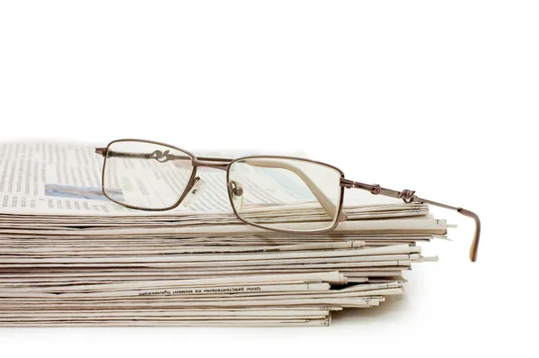 Gafas graduadas en un montón de periódicos — Foto de Stock