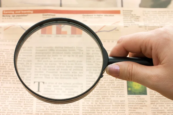 Magnifying glass in hand and text - business background — Stock Photo, Image