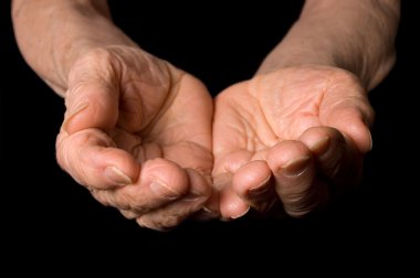 Hands of the old woman on a black background clipart