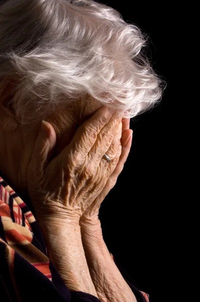 Smutne, stare kobiety z jej ręce na jej twarzy jest przerażeniu — Zdjęcie stockowe