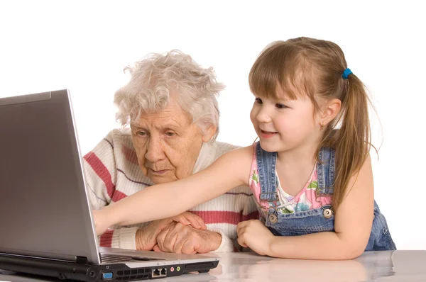 Isoäiti, jolla on lapsenlapsi tietokoneella. — kuvapankkivalokuva
