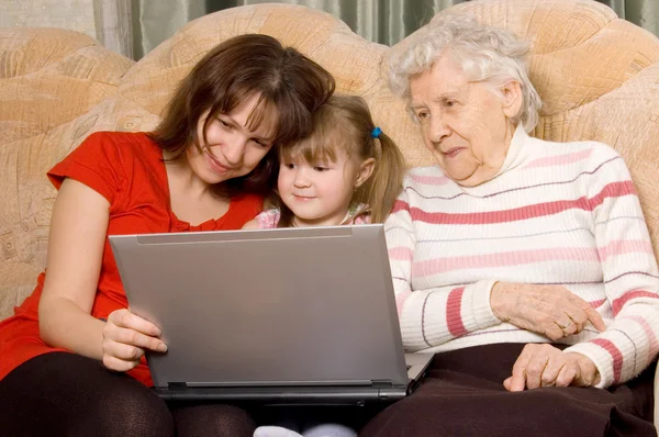 Family on a sofa with the computer — Stock Photo, Image