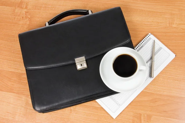 Чорний портфель і кава на столі — стокове фото