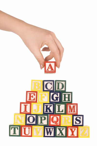 A mão segura um cubo com letras — Fotografia de Stock