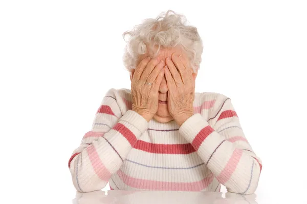 Trieste oude vrouwen met haar handen in haar gezicht is ontzetting — Stockfoto