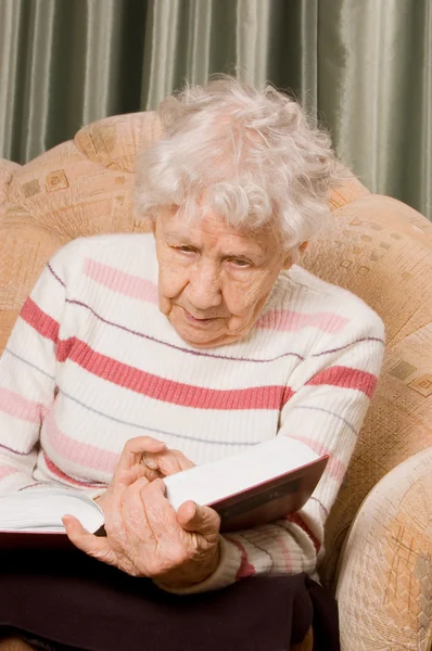 A idosa lê o livro — Fotografia de Stock