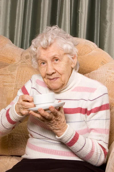 Бабушка с кофе на диване — стоковое фото