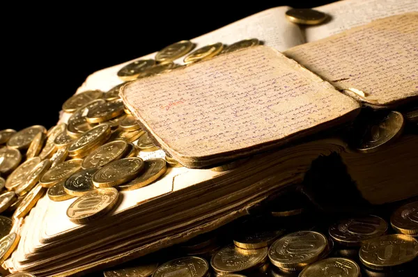 Стара книга з золотими монетами — стокове фото