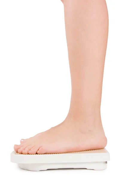 Vrouwelijke voeten op schalen geïsoleerd op wit — Stockfoto