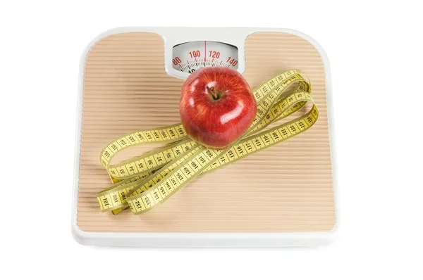 Escala, fita e maçã sobre fundo branco — Fotografia de Stock