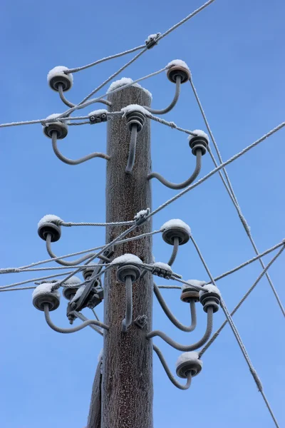 stock image Electrical post in the winter on the blue sky background