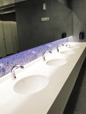 A row of sinks and taps in a public toilet (washroom) clipart