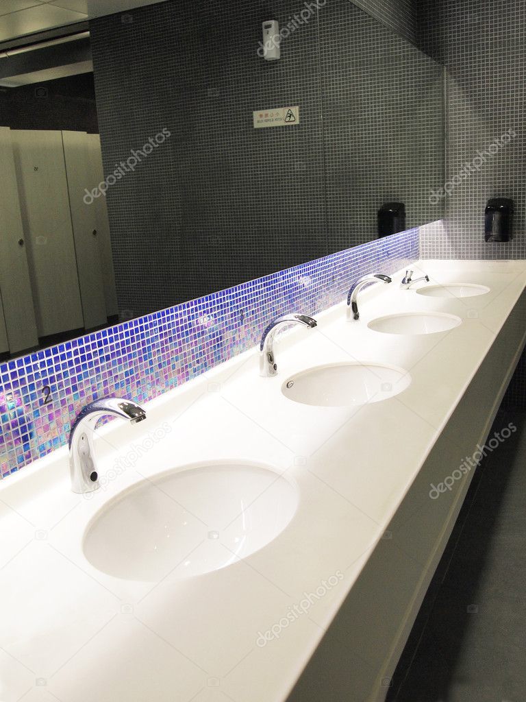 A row of sinks and taps in a public toilet (washroom)