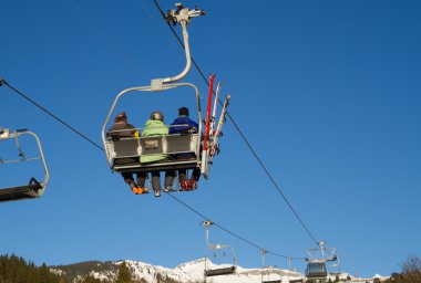 Three men on a chair lift in Flims Switzerland. Taken on Canon 7D clipart